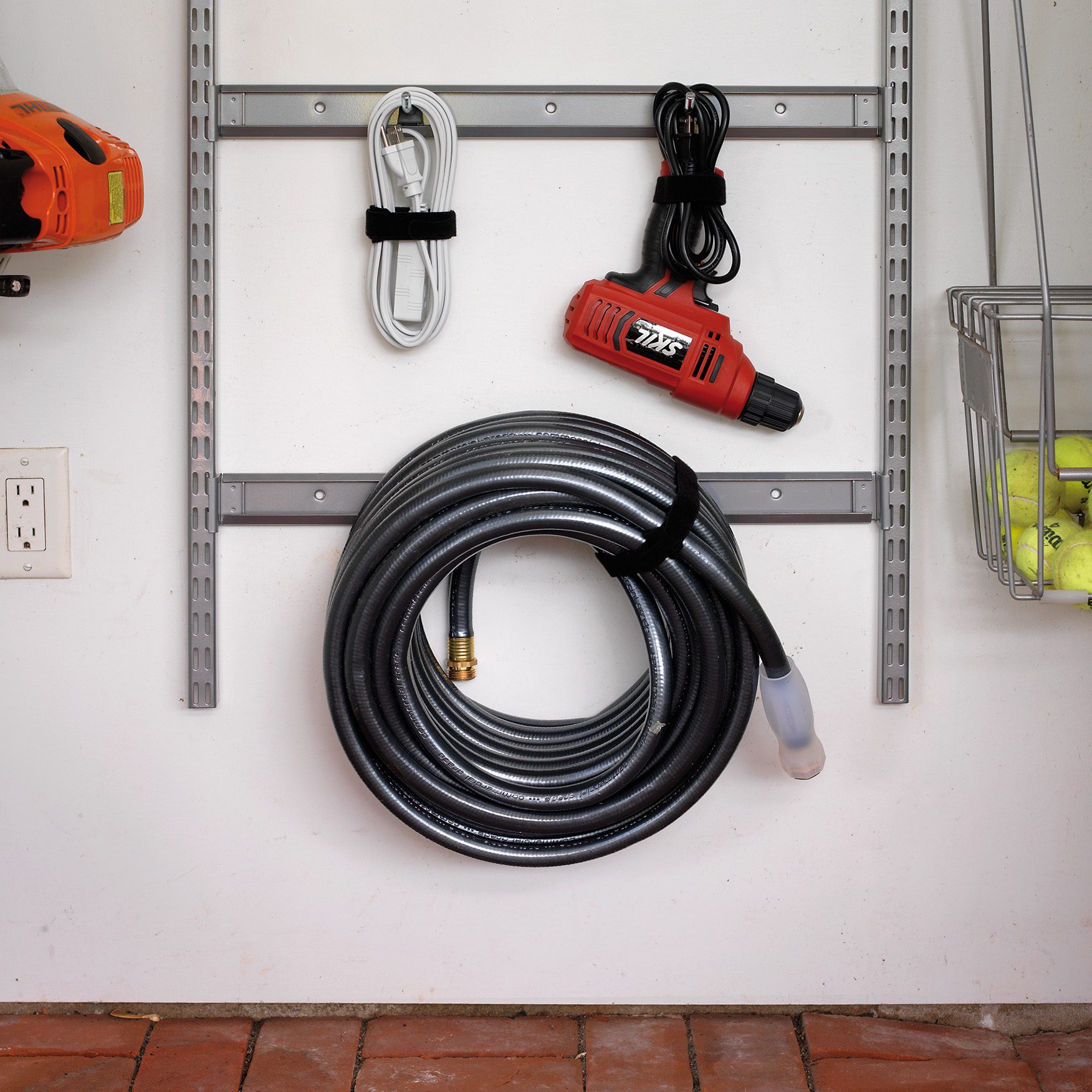 Hose, cables and tools secured and hung on a wall with VELCRO® Brand All-Purpose Straps.