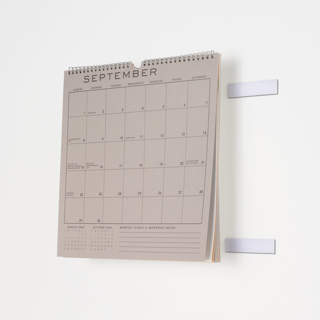 A calander being placed on the wall using VELCRO® Brand Stick On Back Fasteners