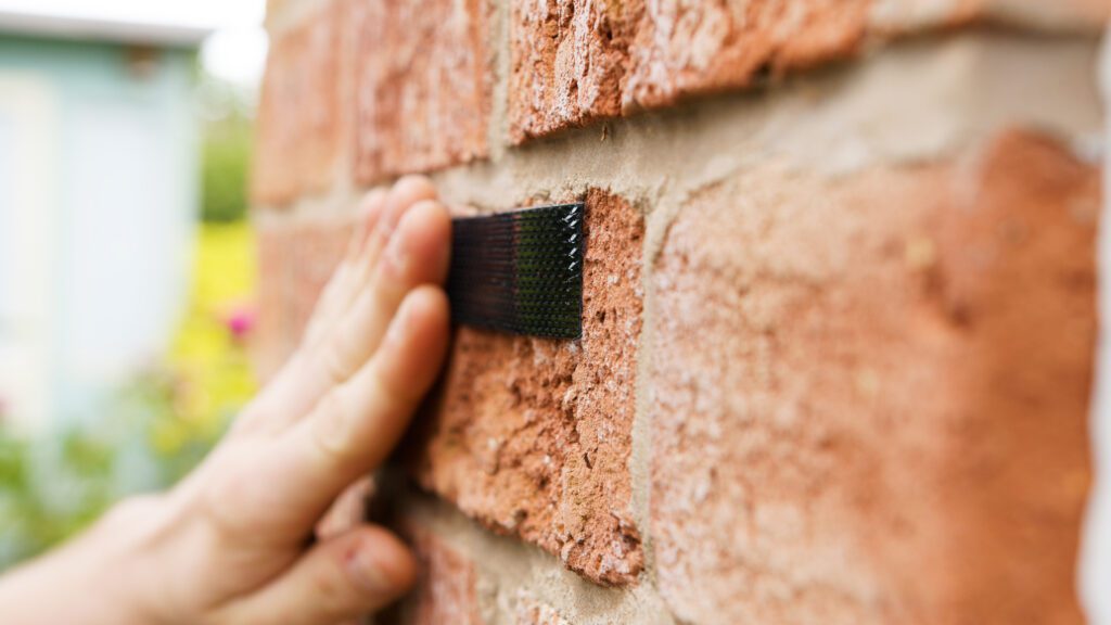 VELCRO® Brand Extreme Lock Fastener being pressed on a wall for outdoor DIY project