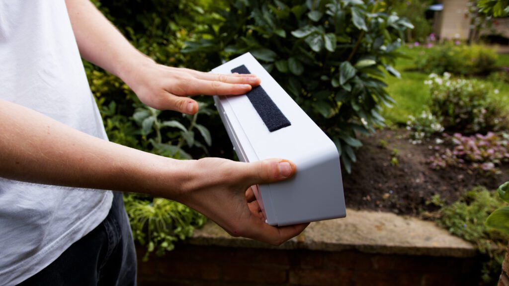 Hand pressing VELCRO® Brand Extreme Lock Fastener on planter for vertical wall garden DIY