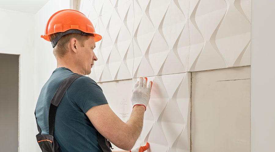 Construction worker installing 3D wall panels using high quality hook and loop for a flexible alternative.
