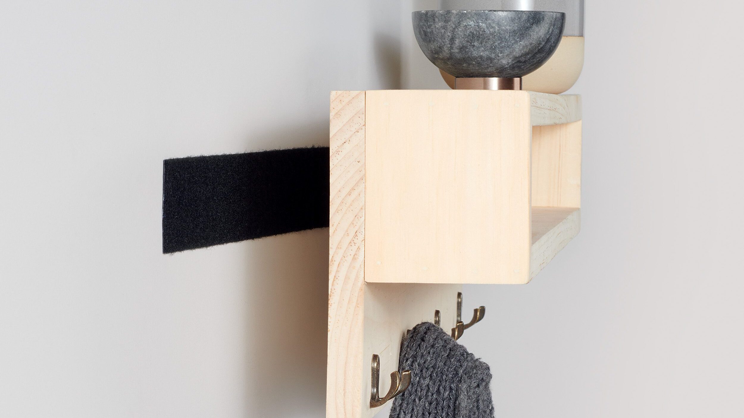 Shelf being mounted with VELCRO® Brand Industrial Strength Tape and no nails