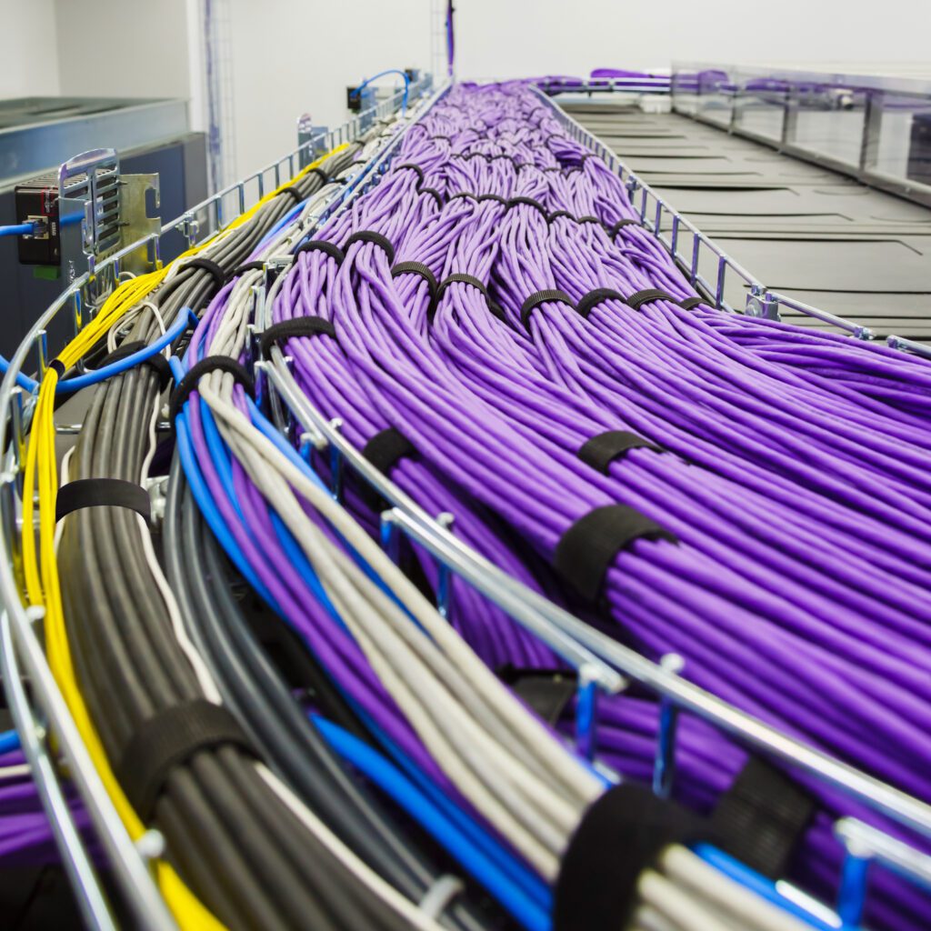 VELCRO® Brand ONE‑WRAP® fasteners secure high‑density purple cable bundles in a cable tray.