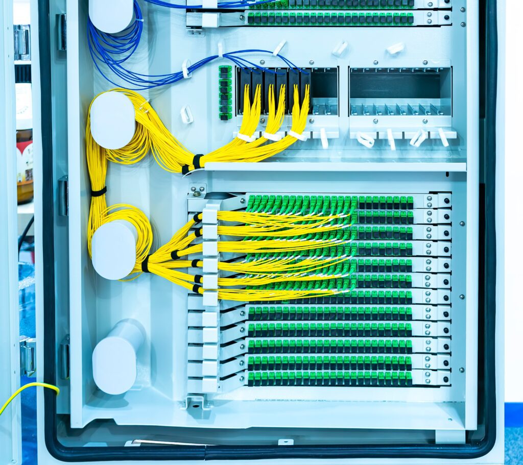 Fiber‑optic patch panel with cable bundles neatly organized in cabinet.