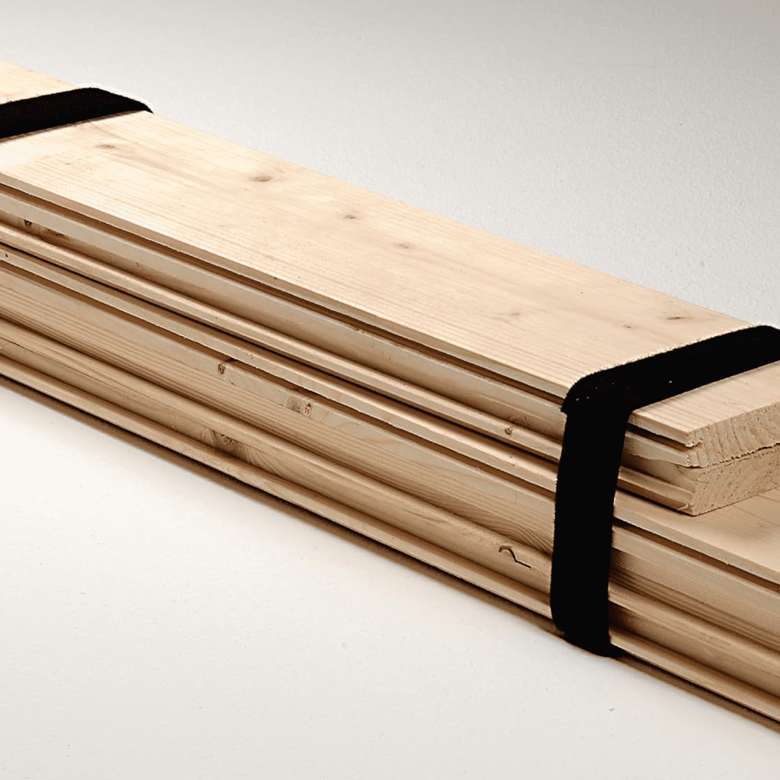 Planks of wood bundled together using VELCRO® Brand ONE-WRAP® Ties for safe transportation.